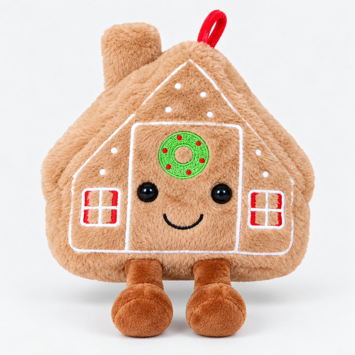 Soft gingerbread house plushie with a smiling face, wreath and little feet