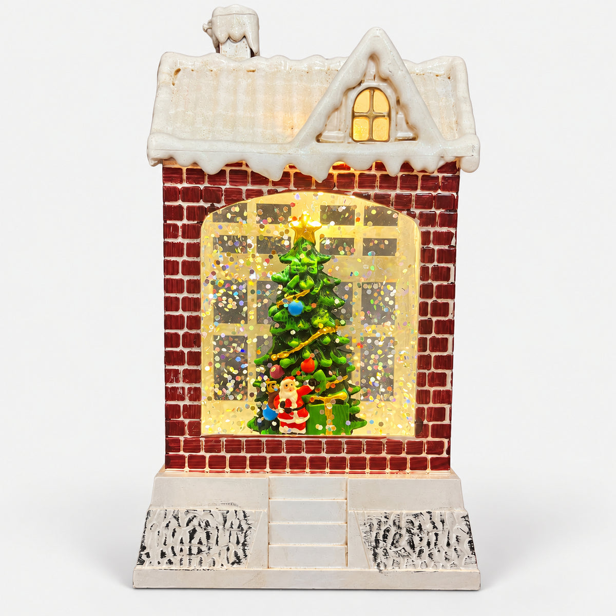 Christmas snowy house decoration lit up with a warm glow