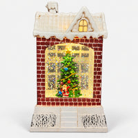 Christmas snowy house decoration lit up with a warm glow