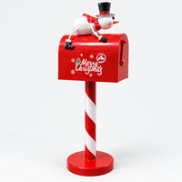 Red Merry Christmas mailbox with a snowman on top and a candy-stripe post