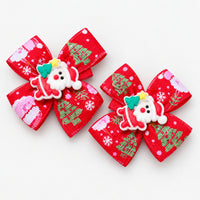Pair of red Christmas bow hair clips with a Santa charm