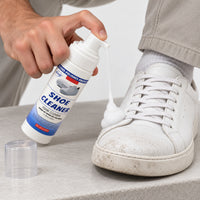 Applying foam shoe cleaner on a dirty white sneaker