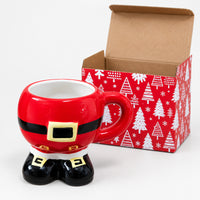 Santa suit boots mug next to its red Christmas tree print box