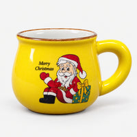 Yellow rounded Christmas mug with Santa and a green gift