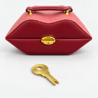 Burgundy lips jewelry case closed with its gold-tone key