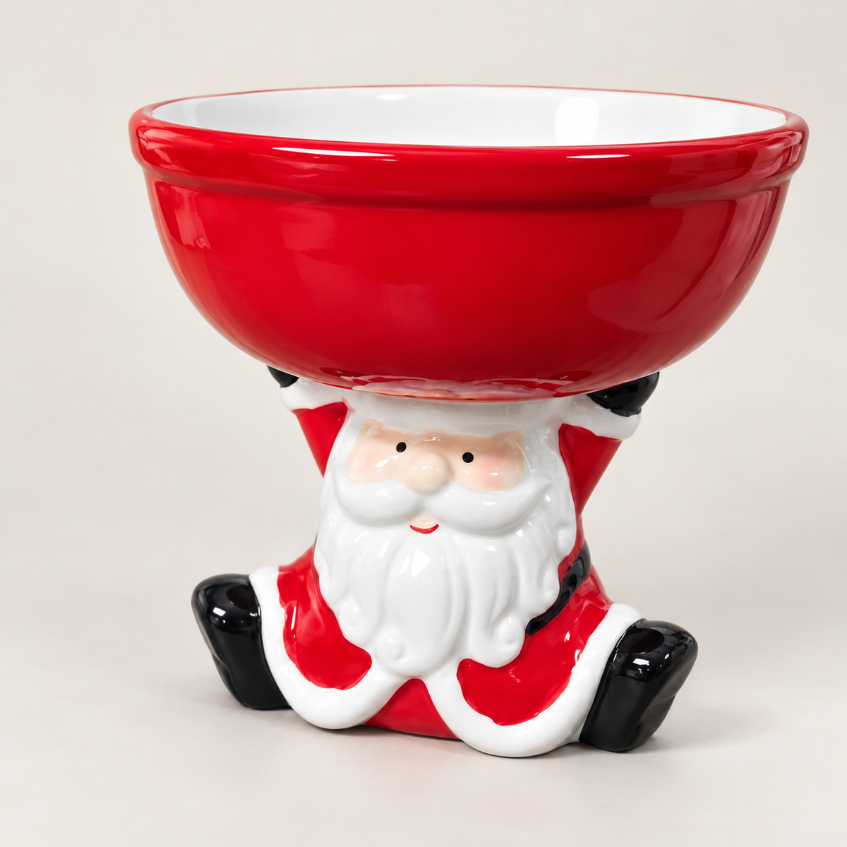 Red Christmas bowl held up by a sitting Santa figure