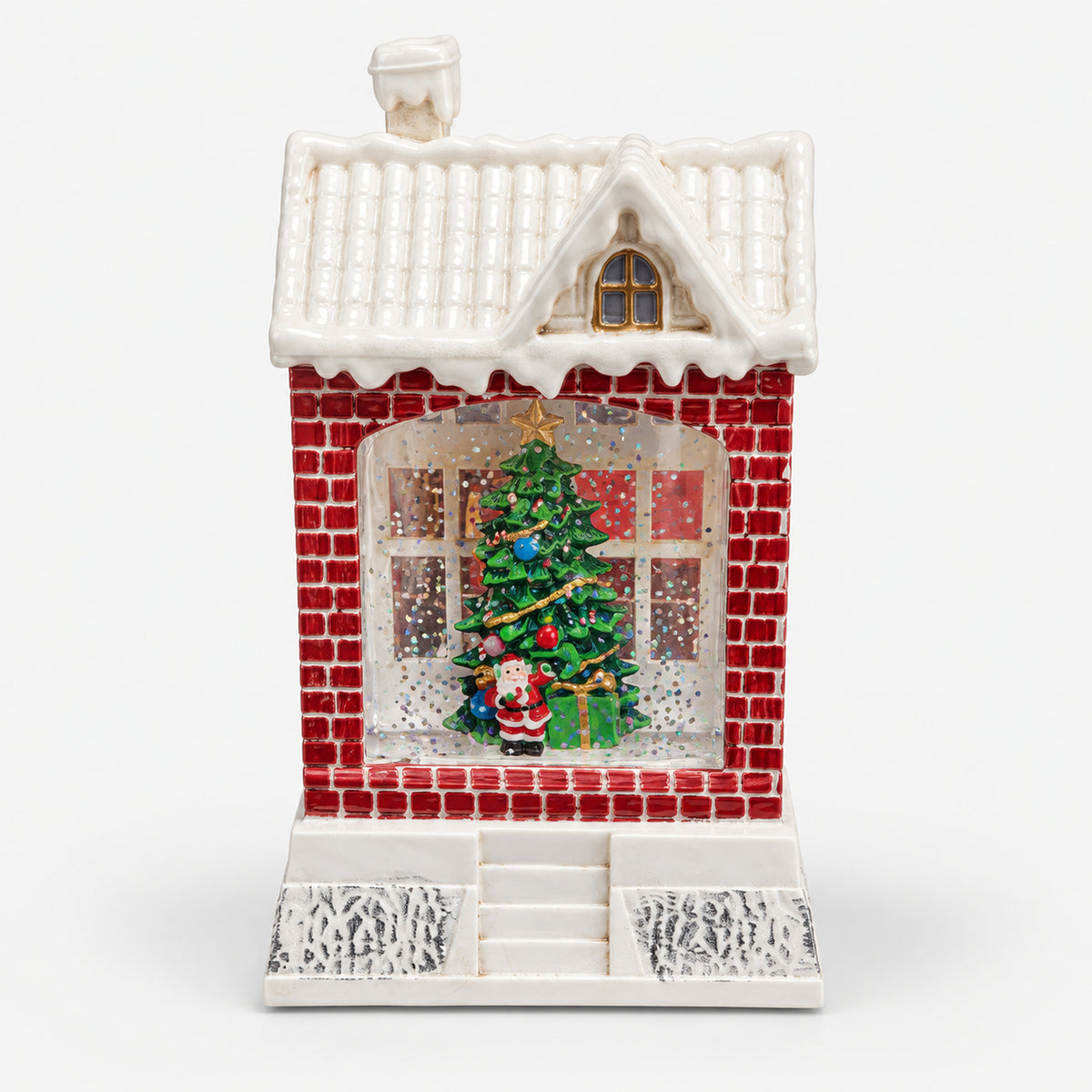 Christmas snowy house decoration with red brick walls and a Christmas tree in the window
