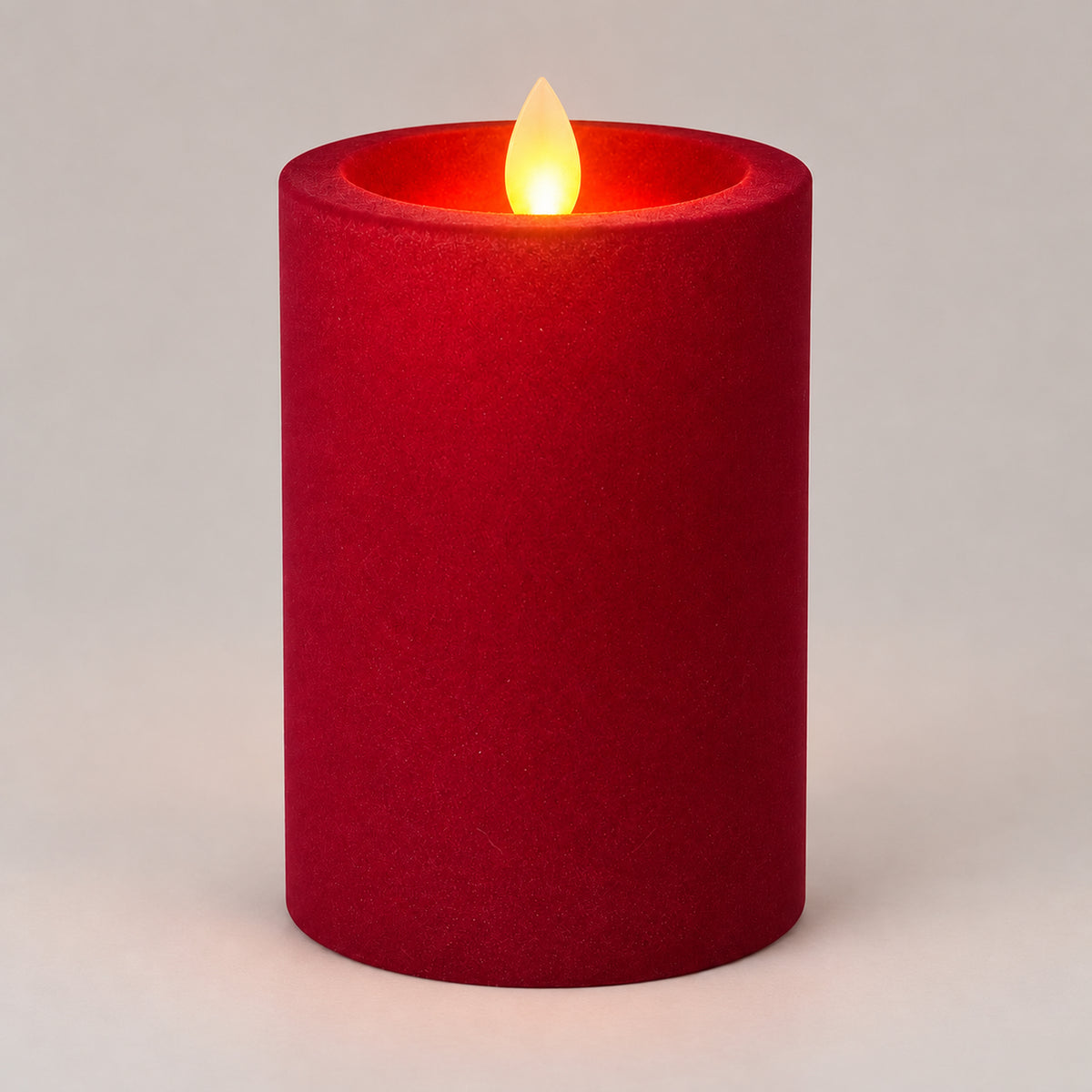 Burgundy 12.5 cm LED pillar candle glowing with a dancing flame