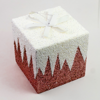 Red glitter gift box decoration seen from above with white icicle drips