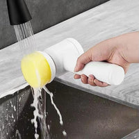 Electric cleaning brush with sponge head rinsed under the tap