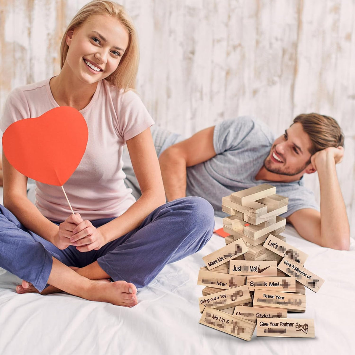 Couple on a bed with the block tower dare game