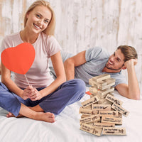 Couple on a bed with the block tower dare game