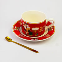 Red Christmas cup and saucer with festive print and gold spoon