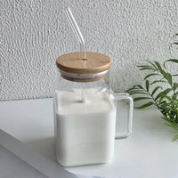 Square glass mason jar filled with milk, with bamboo lid and glass straw