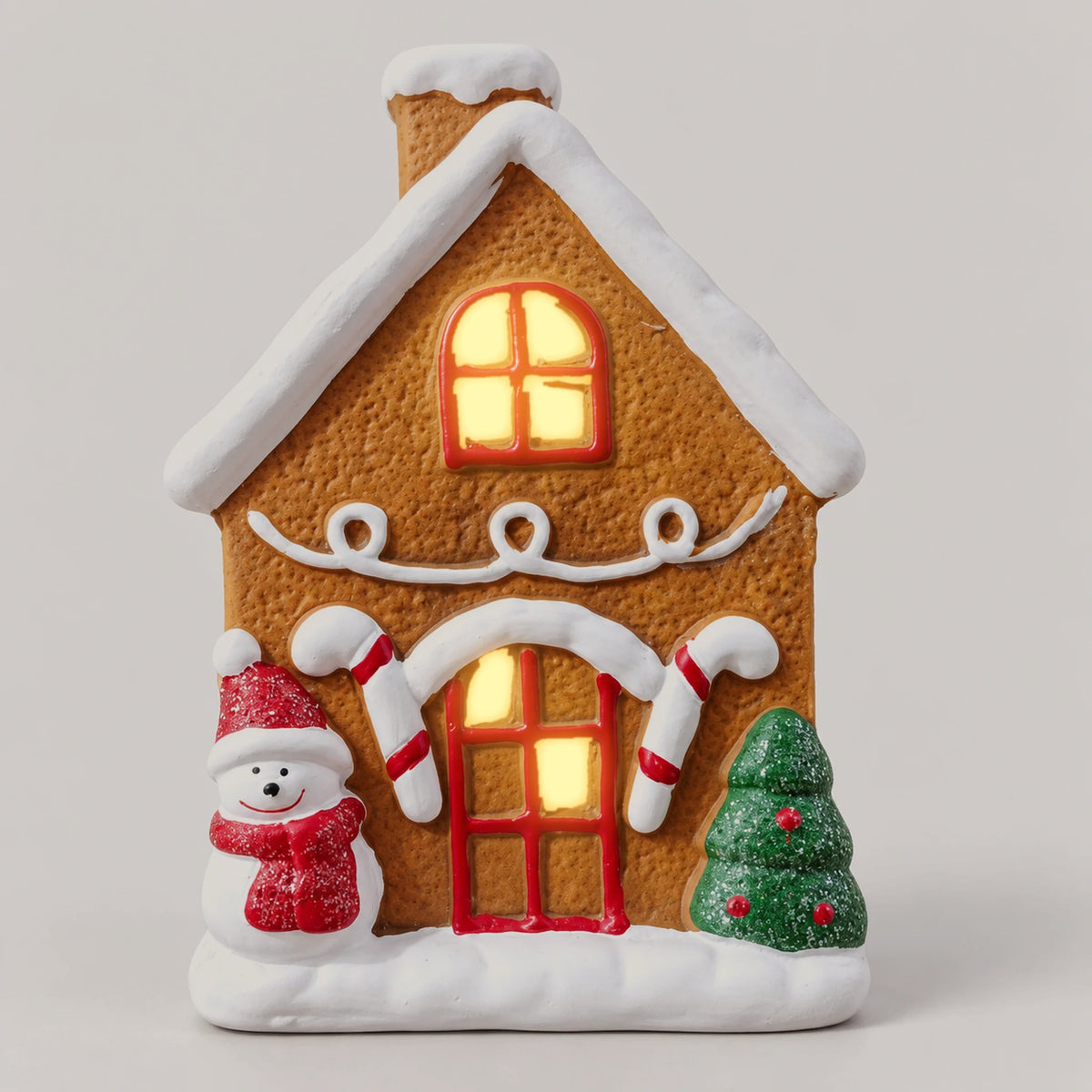 Gingerbread snowman Christmas house with the light on, glowing warm through the windows and door