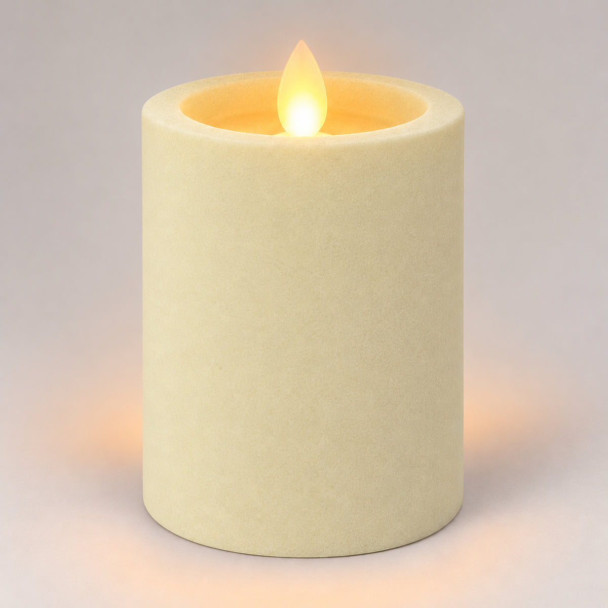 Ivory white 10 cm LED pillar candle glowing with a dancing flame