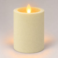 Ivory white 10 cm LED pillar candle glowing with a dancing flame