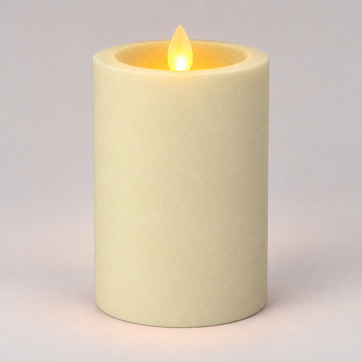 Ivory white 12.5 cm LED pillar candle glowing with a dancing flame