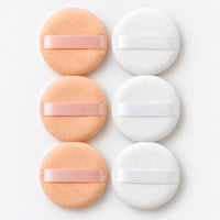 3 peach and 3 white round powder puffs with ribbon straps