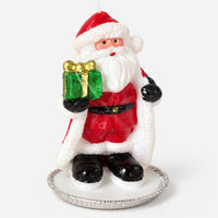 Santa Christmas candle holding a green gift on a silver tray