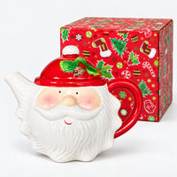Santa face teapot next to its red Christmas print gift box