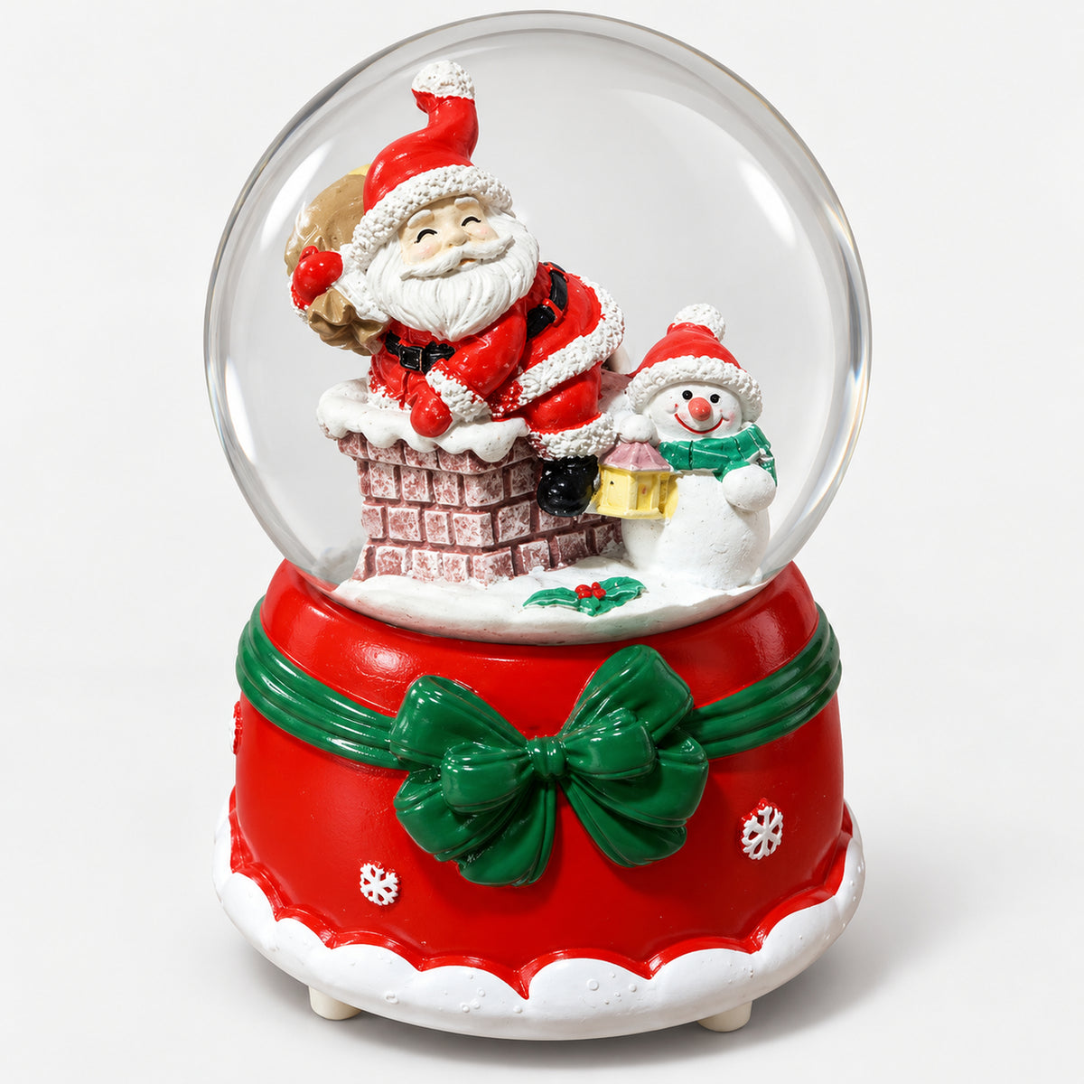 Christmas crystal ball with Santa in a chimney and a snowman, on a red base with a green bow