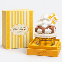 Whipped Pleasure cupcake perfume next to its striped gift box